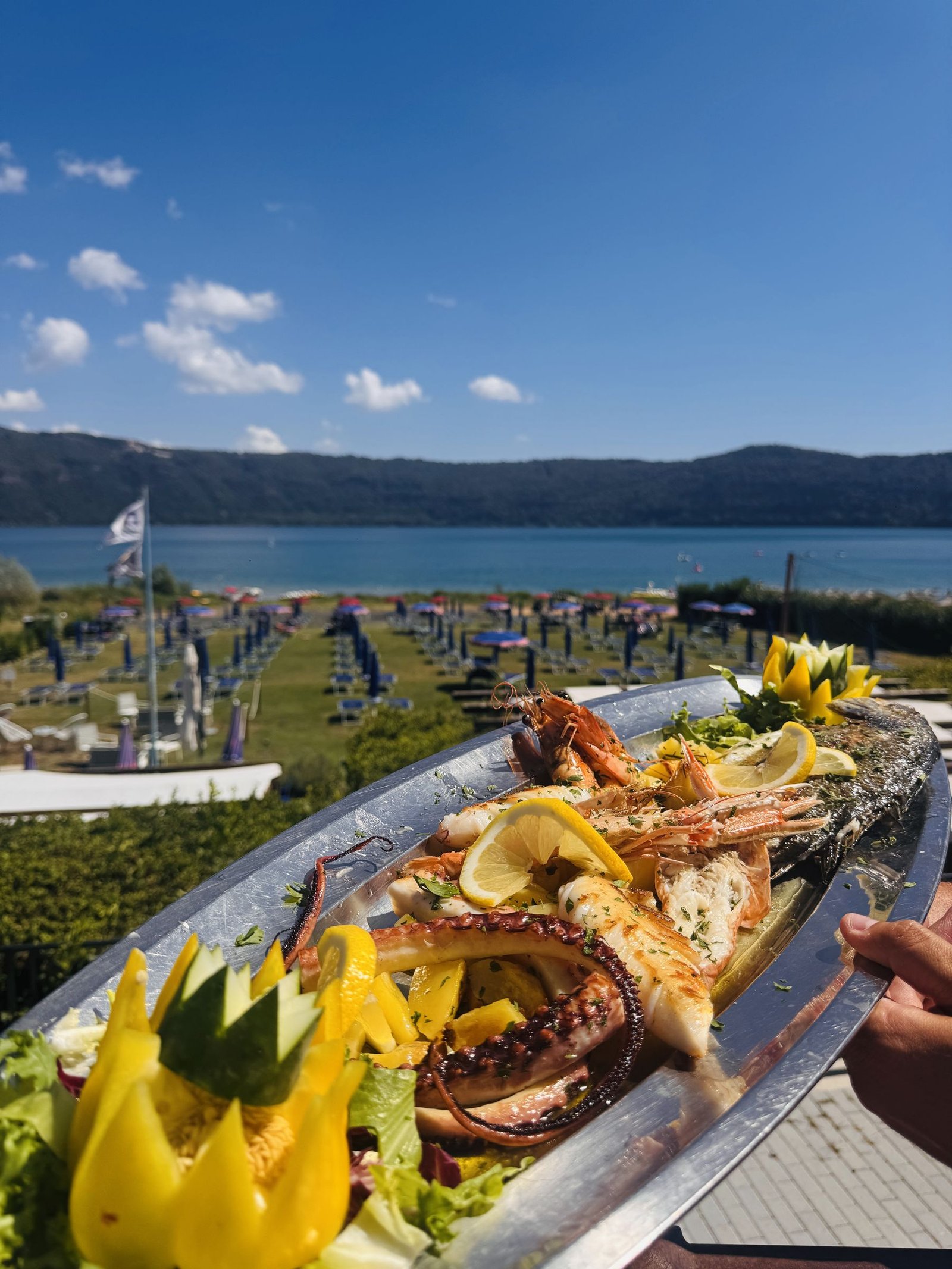 Grigliata mista di pesce servita con il lago sullo sfondo